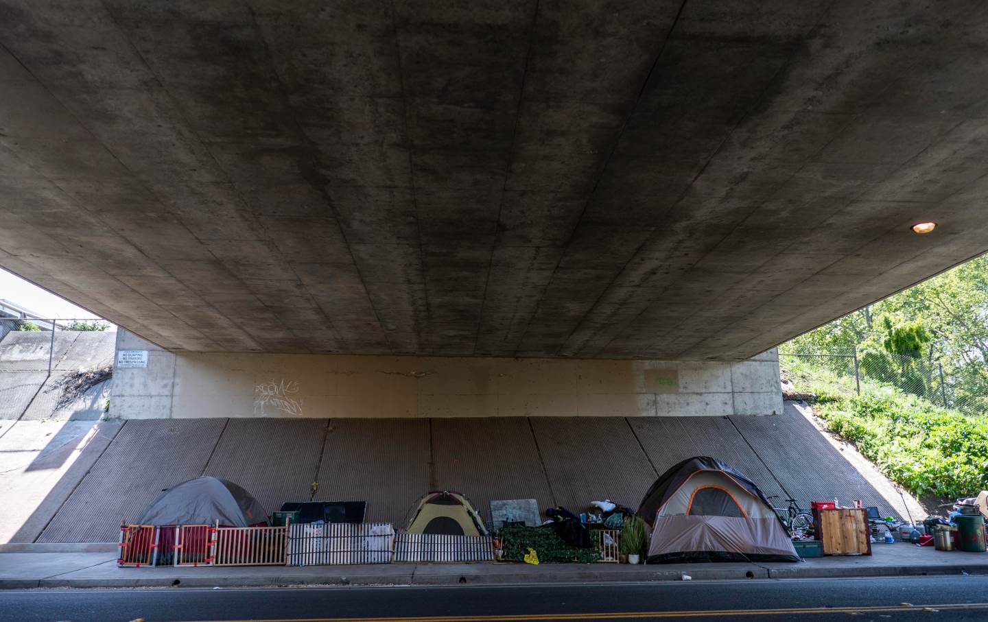 A homeless encampment of tents neatly sit underneath the I-5 freeway in Sacramento, Calif., on Sunday, April 3, 2022.