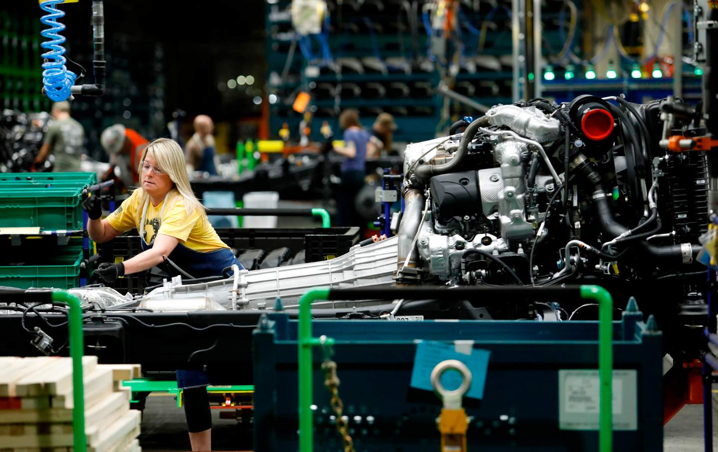 Line workers work on the chassis of full-size General Motors pickup trucks at the Flint Assembly plant on June 12, 2019 in Flint, Michigan.