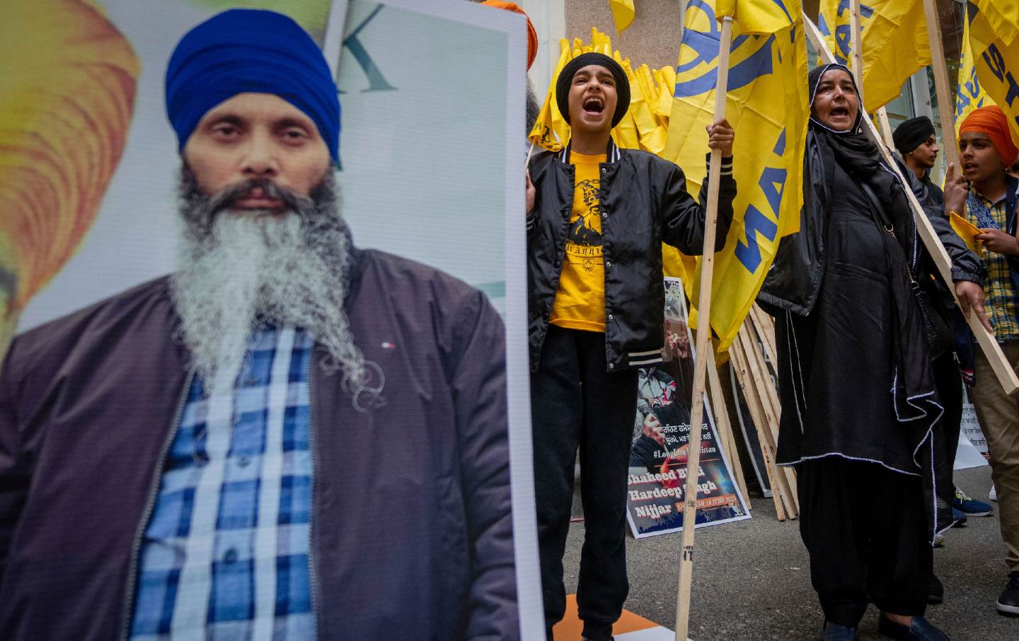Protesters chant after the death of Hardeep Singh Nijjar, with a photo of SIngh Nijjar on the left
