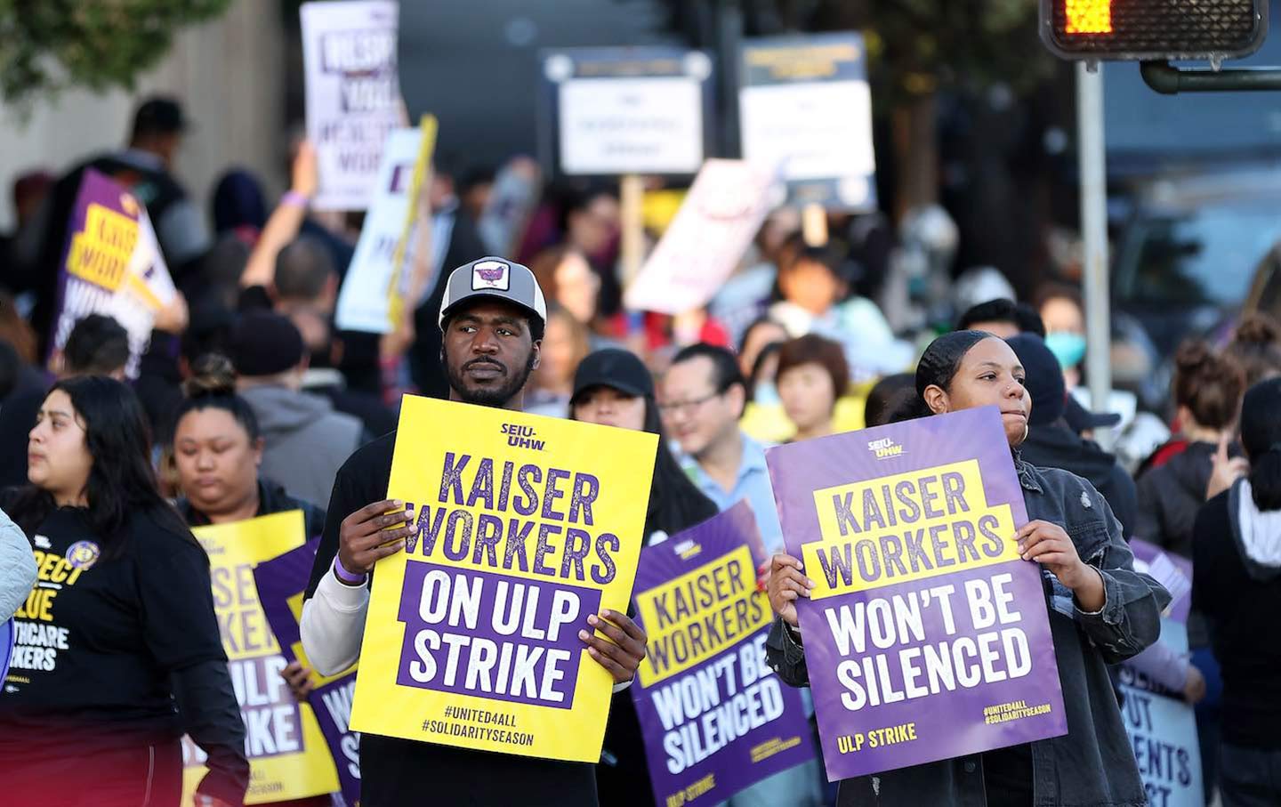 Striking Kaiser Permanente workers hold signs as they march in front of the Kaiser Permanente San Francisco Medical Center on October 4, 2023, in San Francisco.