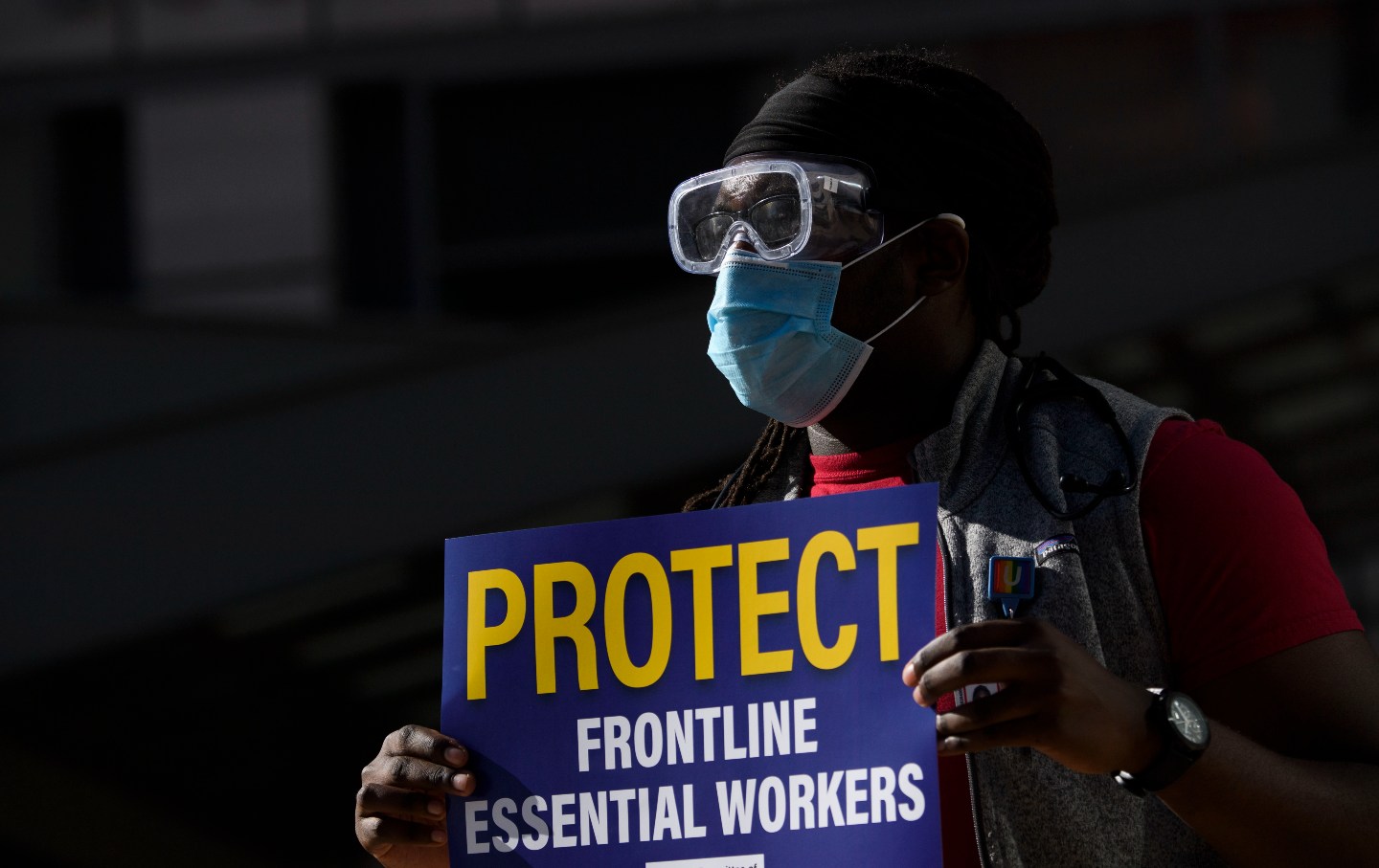 A doctor carries a sign in support of physicians, residents, interns, and fellows at UCLA Health as they protest for improved Covid-19 testing and workplace safety policies outside of UCLA Medical Center in Los Angeles.