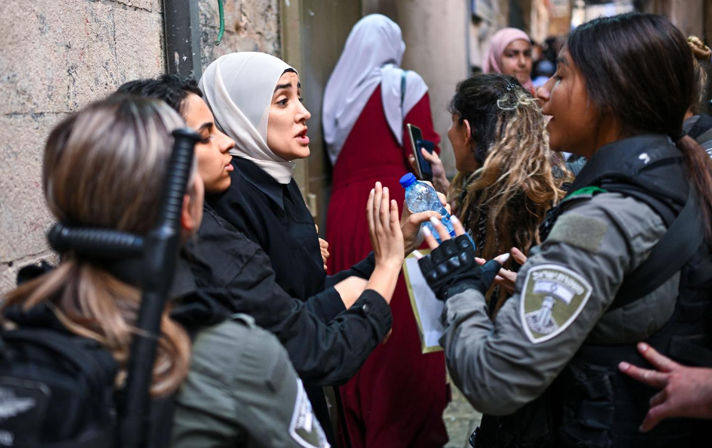 Palestinian women are stopped by members of the Israeli security forces in the old city of Jerusalem as they arrive for the Friday noon prayer on October 13, 2023.