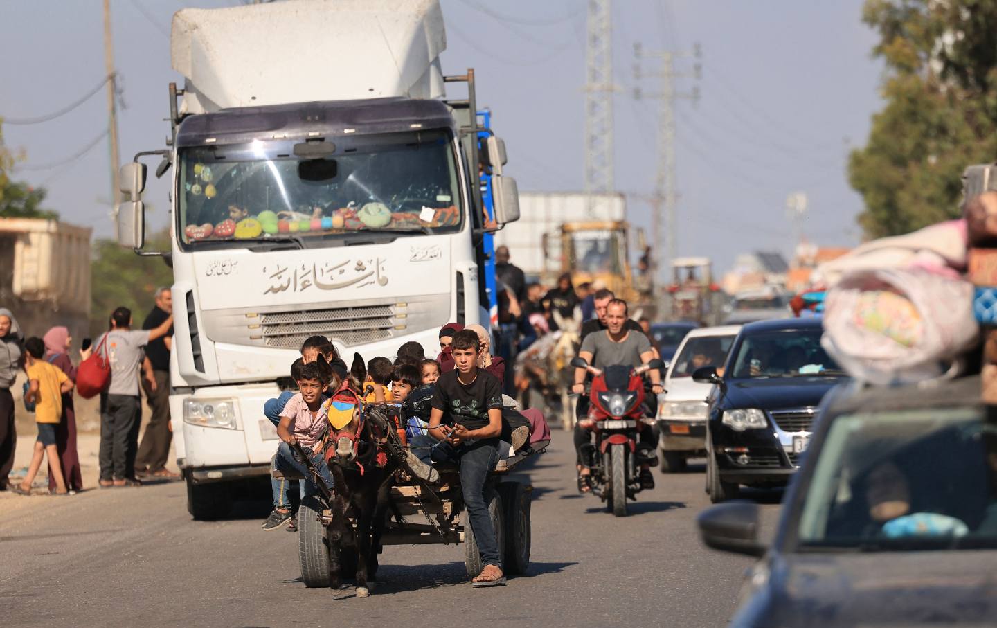 Palestinians carrying their belongings flee following the Israeli army's warning to leave their homes and move south before an expected ground offensive, in Gaza City on October 13, 2023.