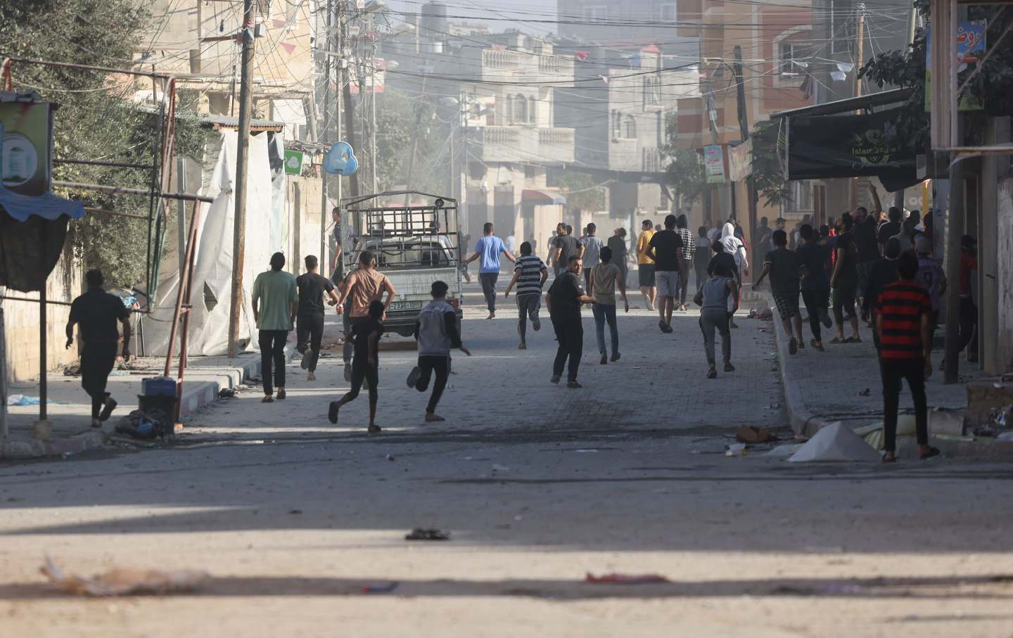 Palestinians run for cover during an Israeli airstrike in Rafah in the southern Gaza Strip on October 18, 2023.