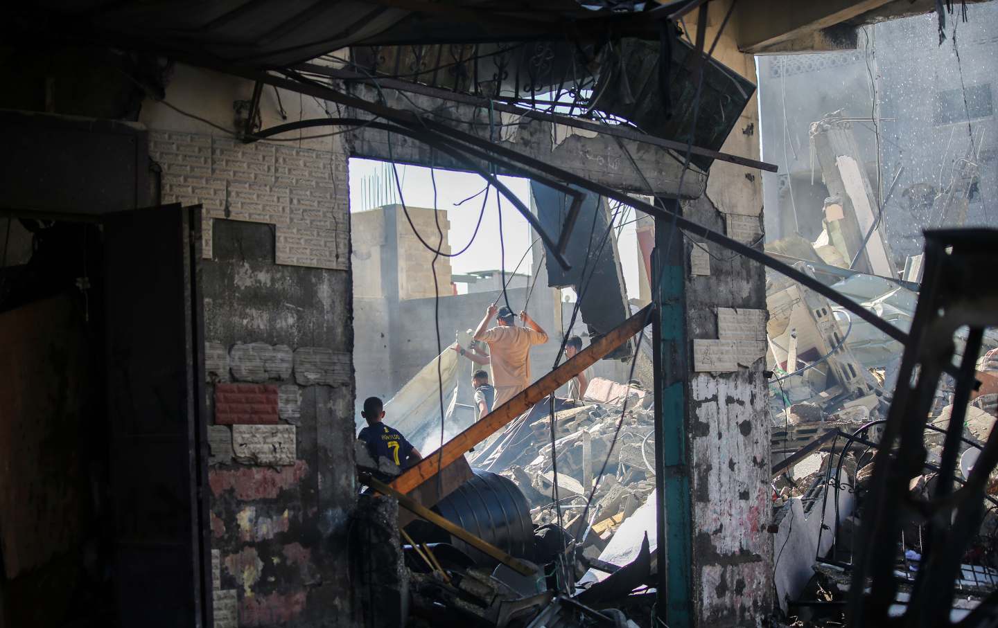 Palestinian emergency services and local citizens search for victims in buildings destroyed during Israeli raids in the southern Gaza Strip on October 17, 2023 in Khan Yunis, Gaza.