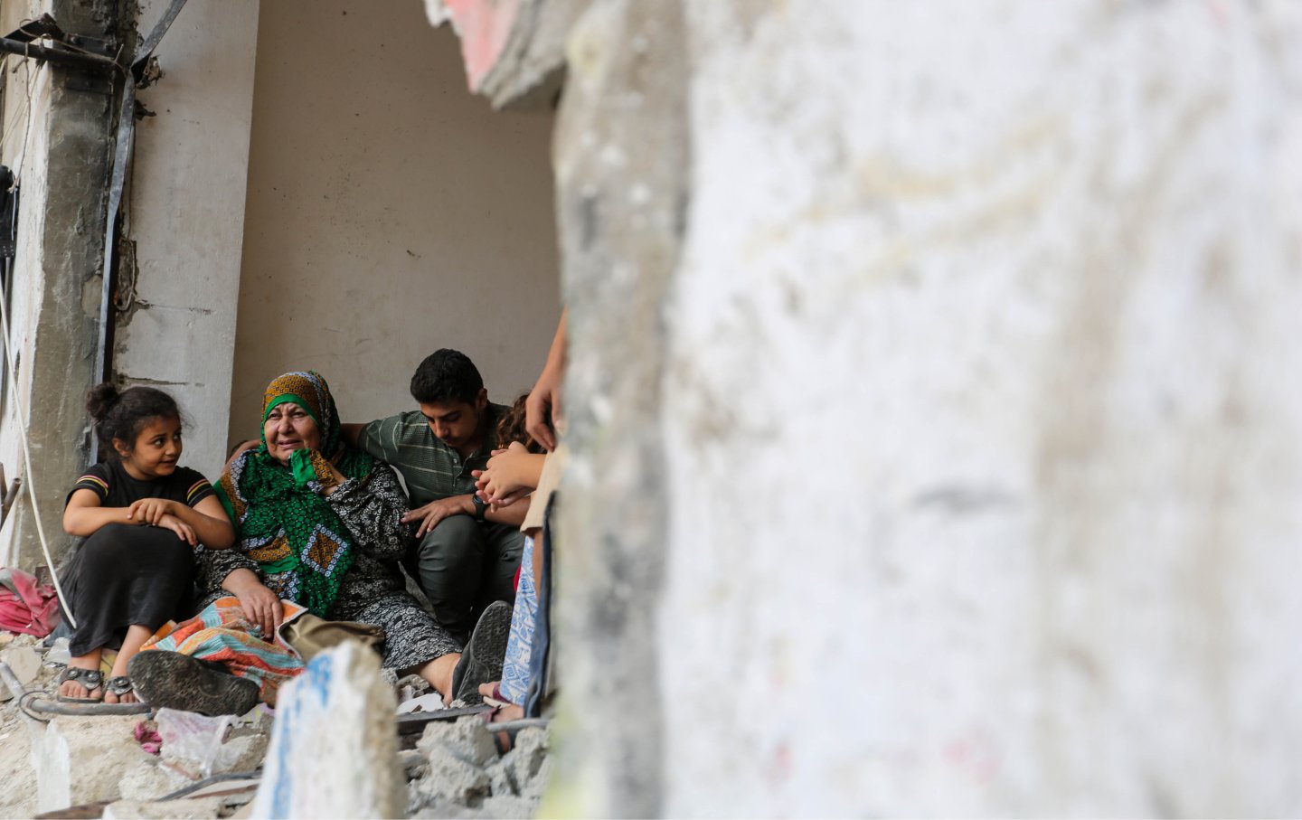 A woman is consoled as people search through buildings that were destroyed during Israeli air raids in the southern Gaza Strip on October 26, 2023 in Khan Yunis, Gaza.