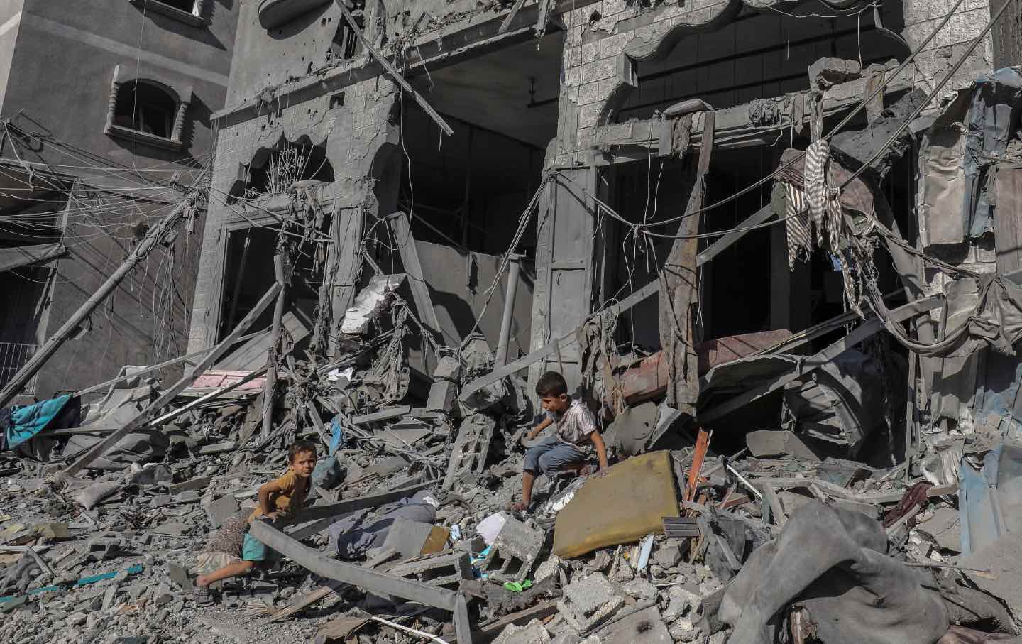 Palestinian children amid rubble of buildings bombed by Israel