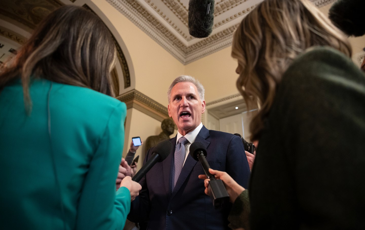 Kevin McCarthy speaking to two reporters in the Capitol.