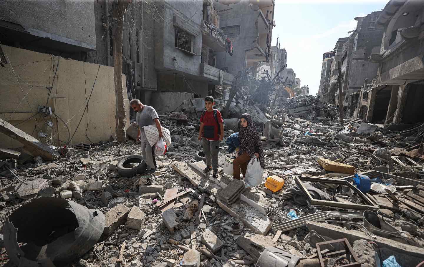 Palestinians in the rubble of their homes after continued bombing that has killed over 1,000 children