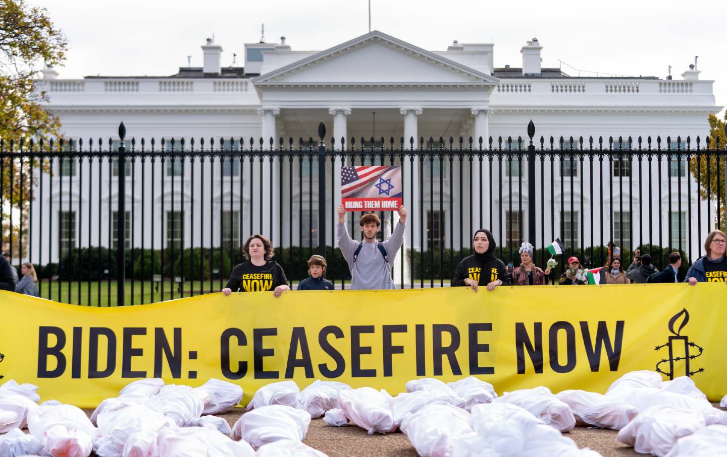 Protesters stand in front of the White House holding a sign calling on President Joe Biden to negotiate a cease-fire in the Israel-Gaza War, Wednesday, November 15, 2023.