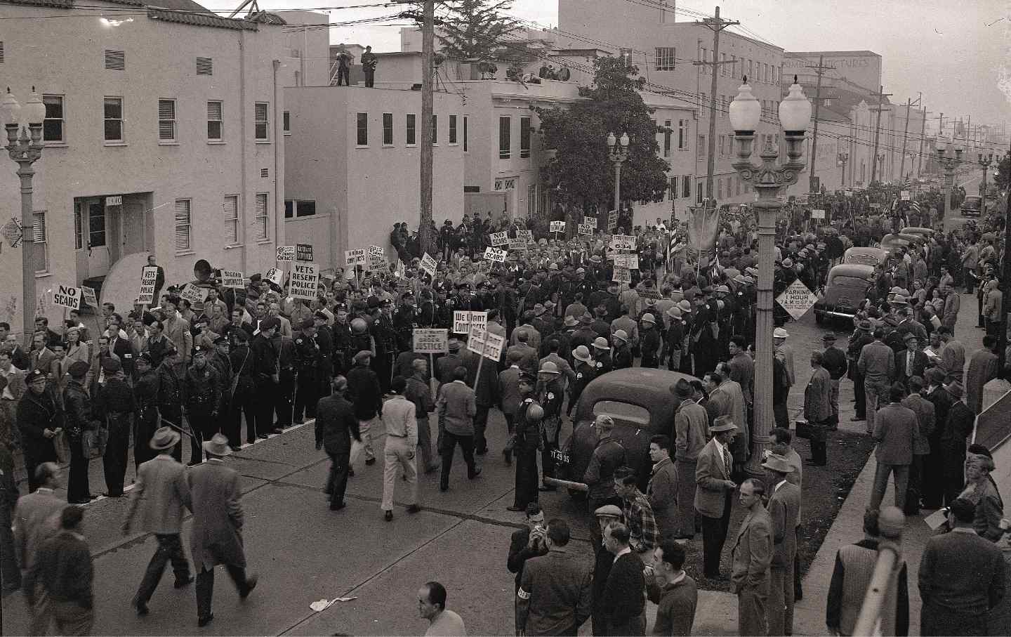 Pickets march between rows of watchful police during the biggest demonstration yet staged by The Conference of Studio Unions, at Columbia Studios during the move strike on Oct. 26, 1946.