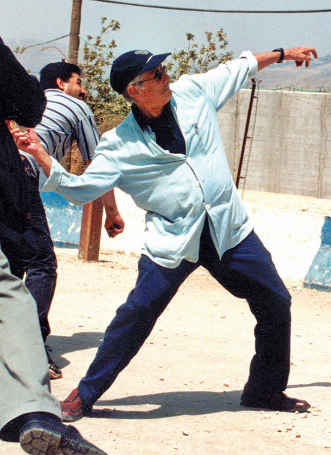 Edward Said throws a stone in the direction of Israel’s boarder fence with Lebanon in July 20.