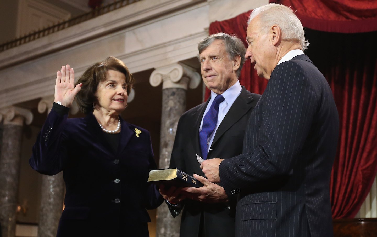 Senator Dianne Feinstein participates in a reenacted swearing-in with her husband Richard C. Blum and then–Vice President Joe Biden in the Old Senate Chamber at the US Capitol January 3, 2013, in Washington, D.C.