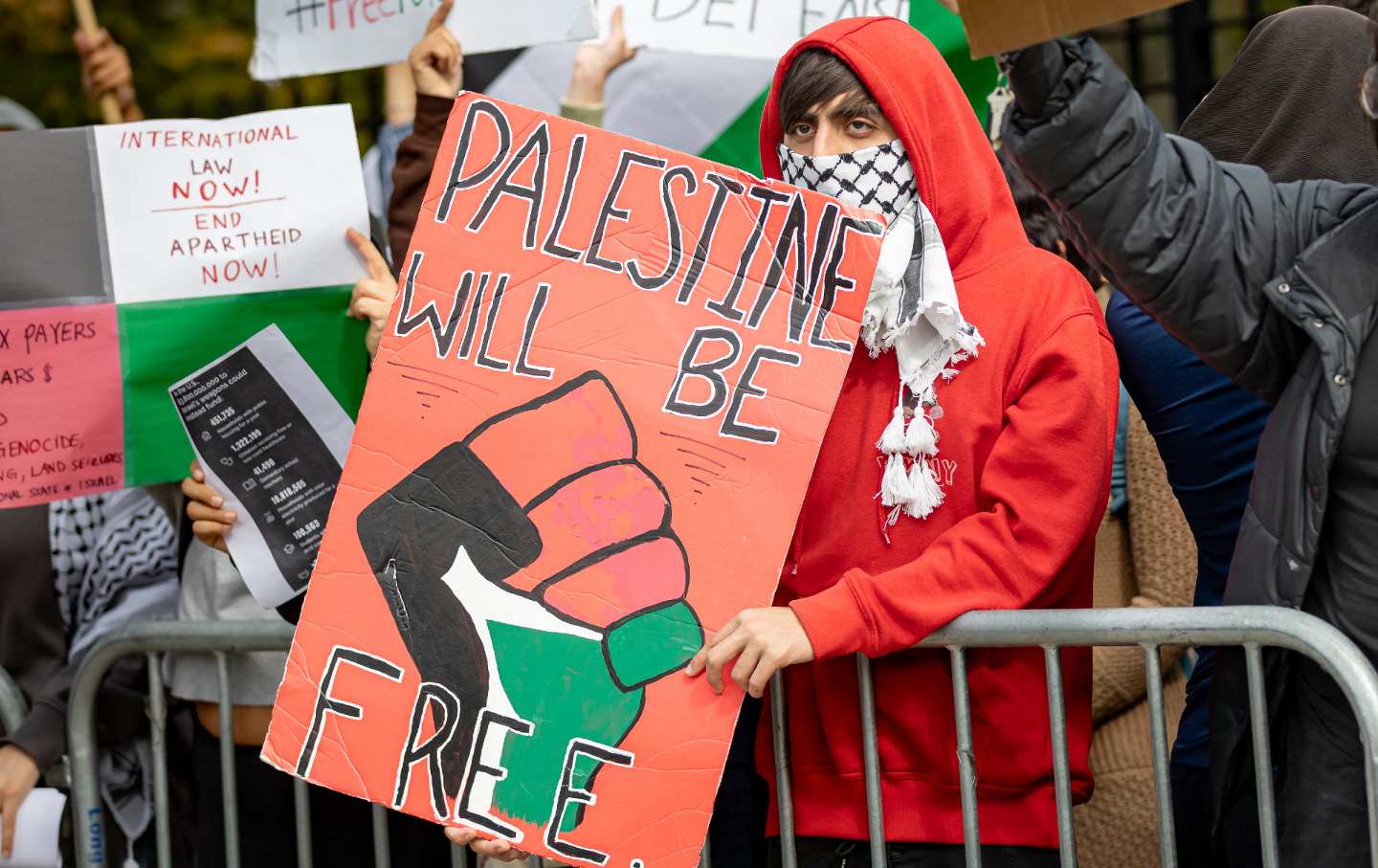 Students from Brooklyn College and supporters hold signs during a pro-Palestinian demonstration at the entrance of the campus.