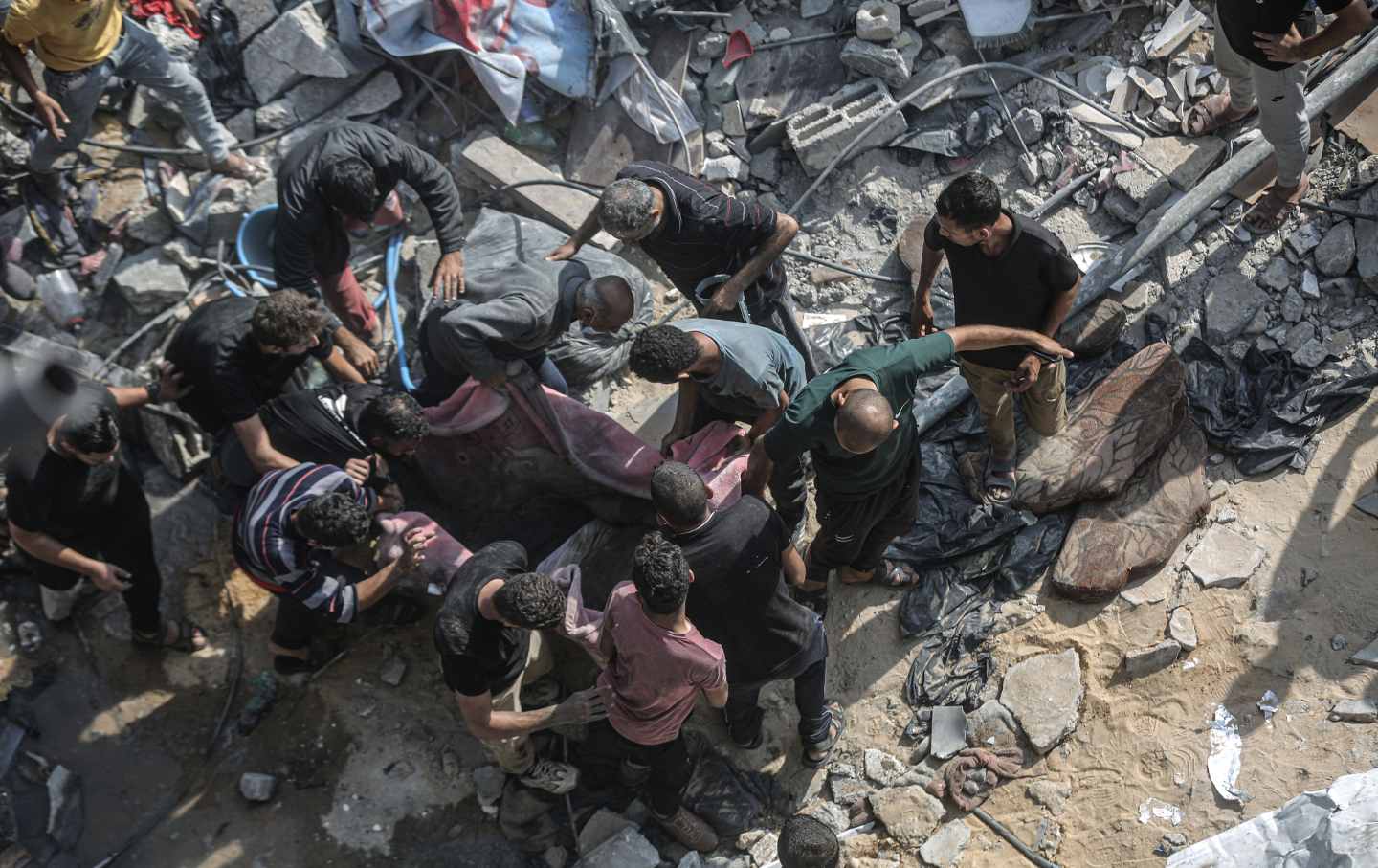 People carry a body, covered with a blanket, as they conduct a search and rescue operation after the second bombardment of the Israeli army in the last 24 hours at Jabalia refugee camp in Gaza City, Gaza on November 01, 2023.