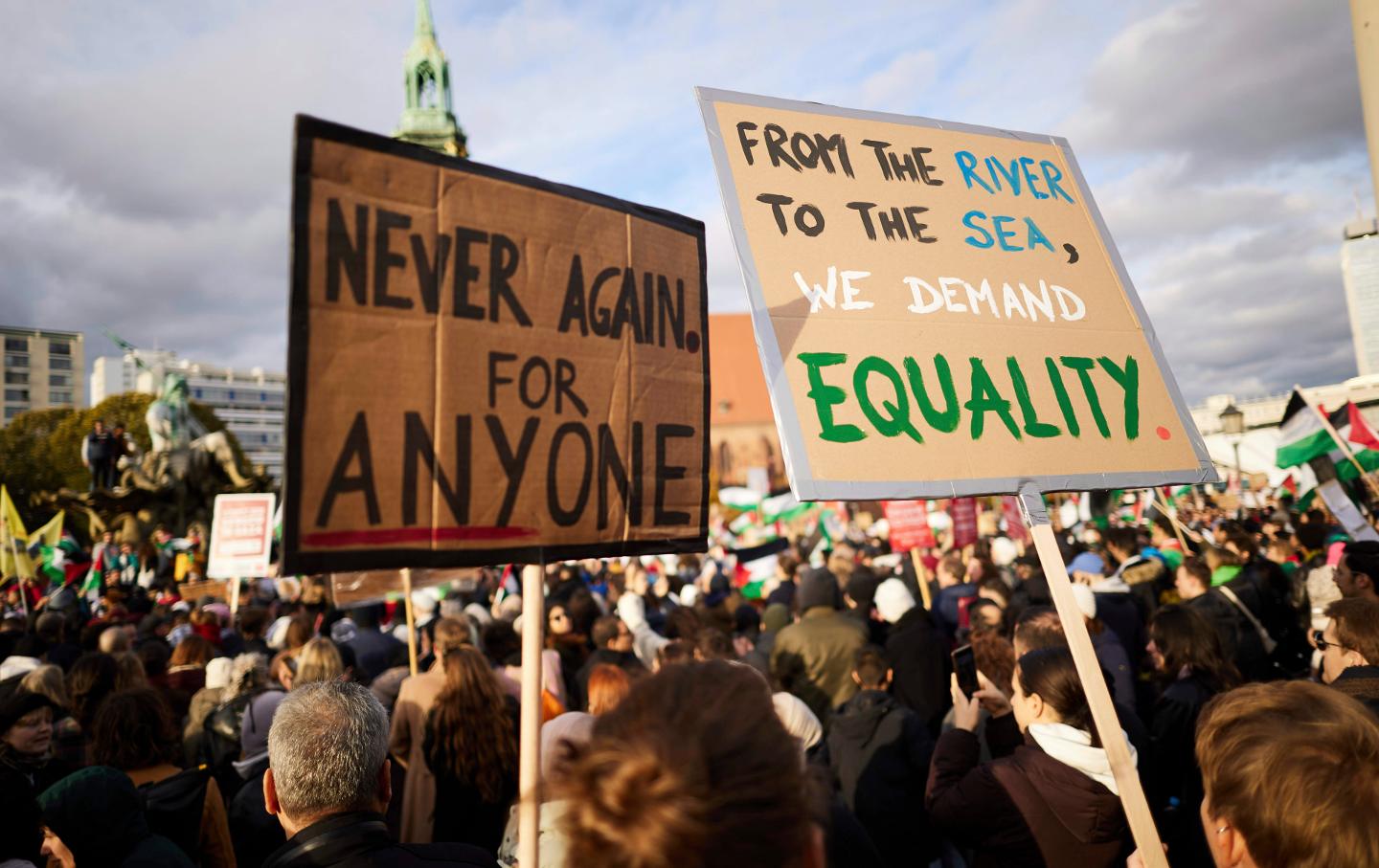 Participants at a pro-Palestine rally at the Neptune Fountain hold a banner reading