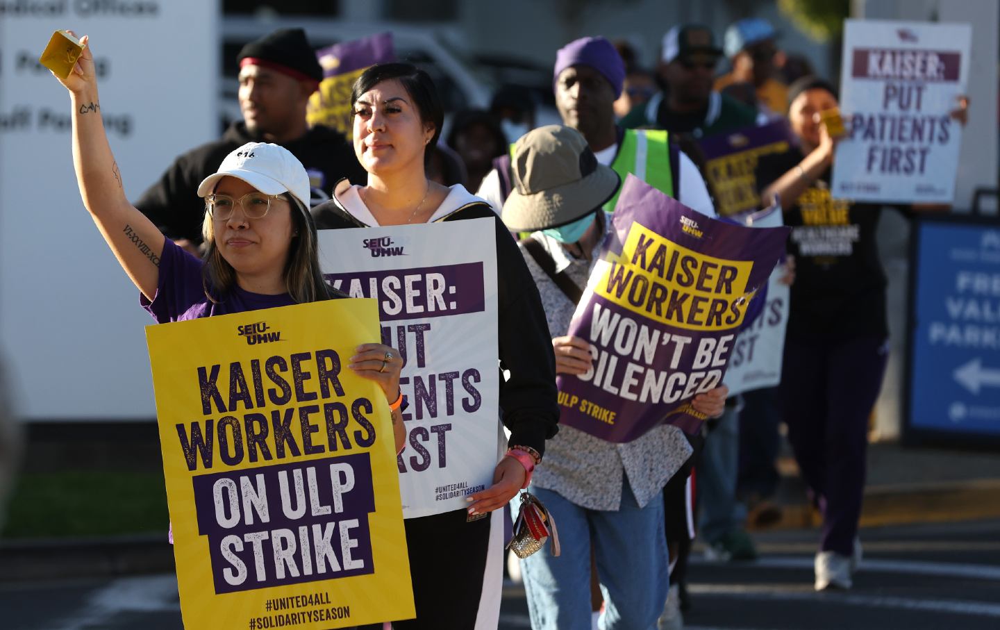 Kaiser Permanente workers on strike marching with signs on a picket line
