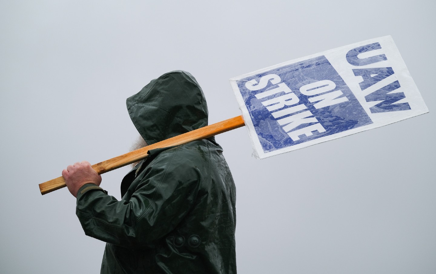 Worker holds a UAW picket sign