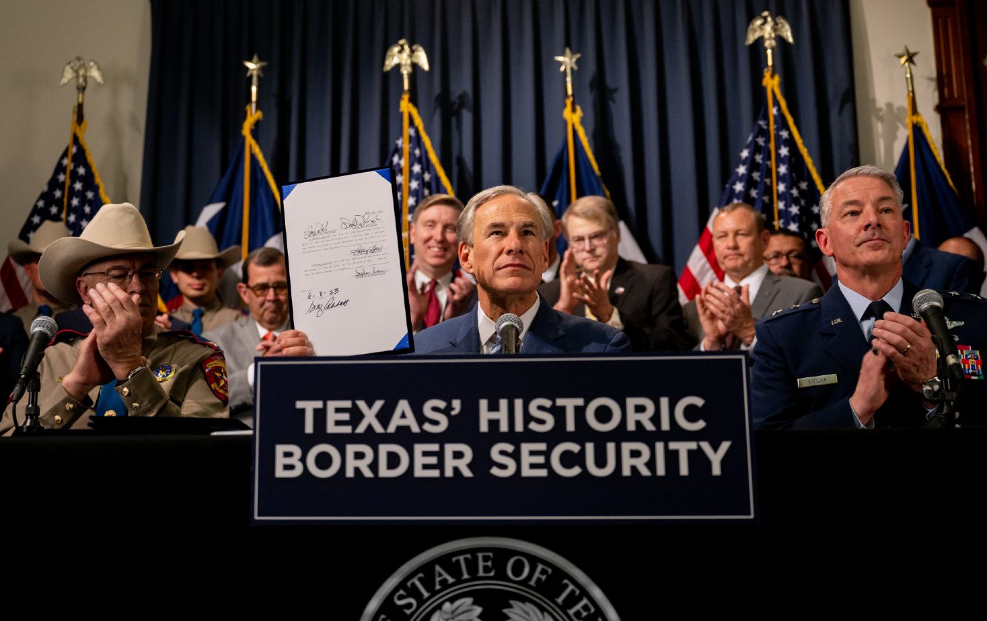 Texas Governor Greg Abbott displays a signed border-security bill during a news conference at the Texas State Capitol on June 8, 2023.