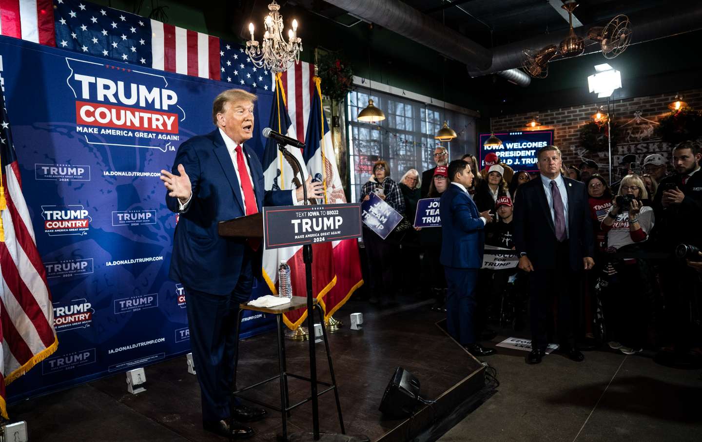 Donald Trump speaks to a crowd animatedly in front of a 