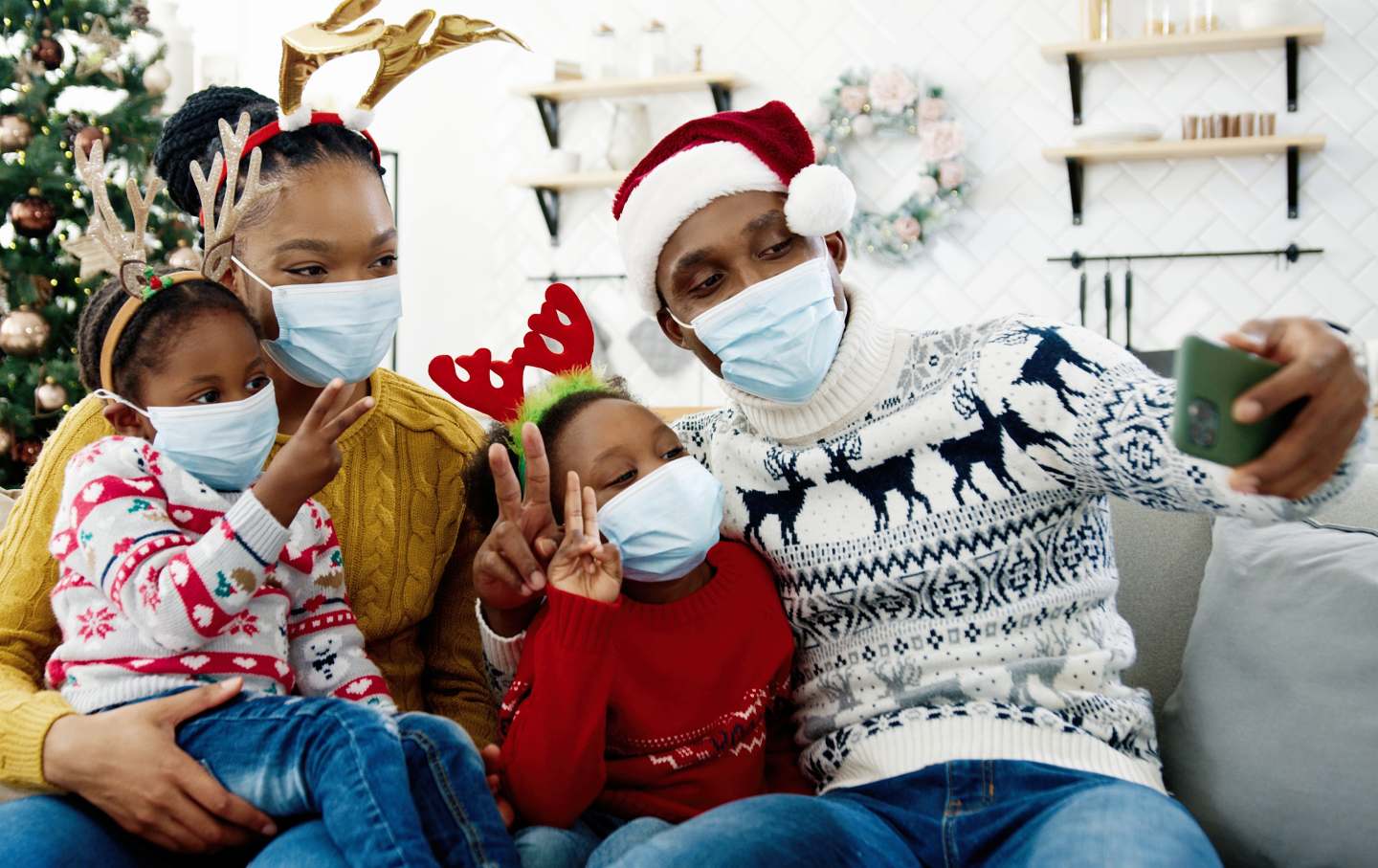 A family in masks taking pictures on smartphone.