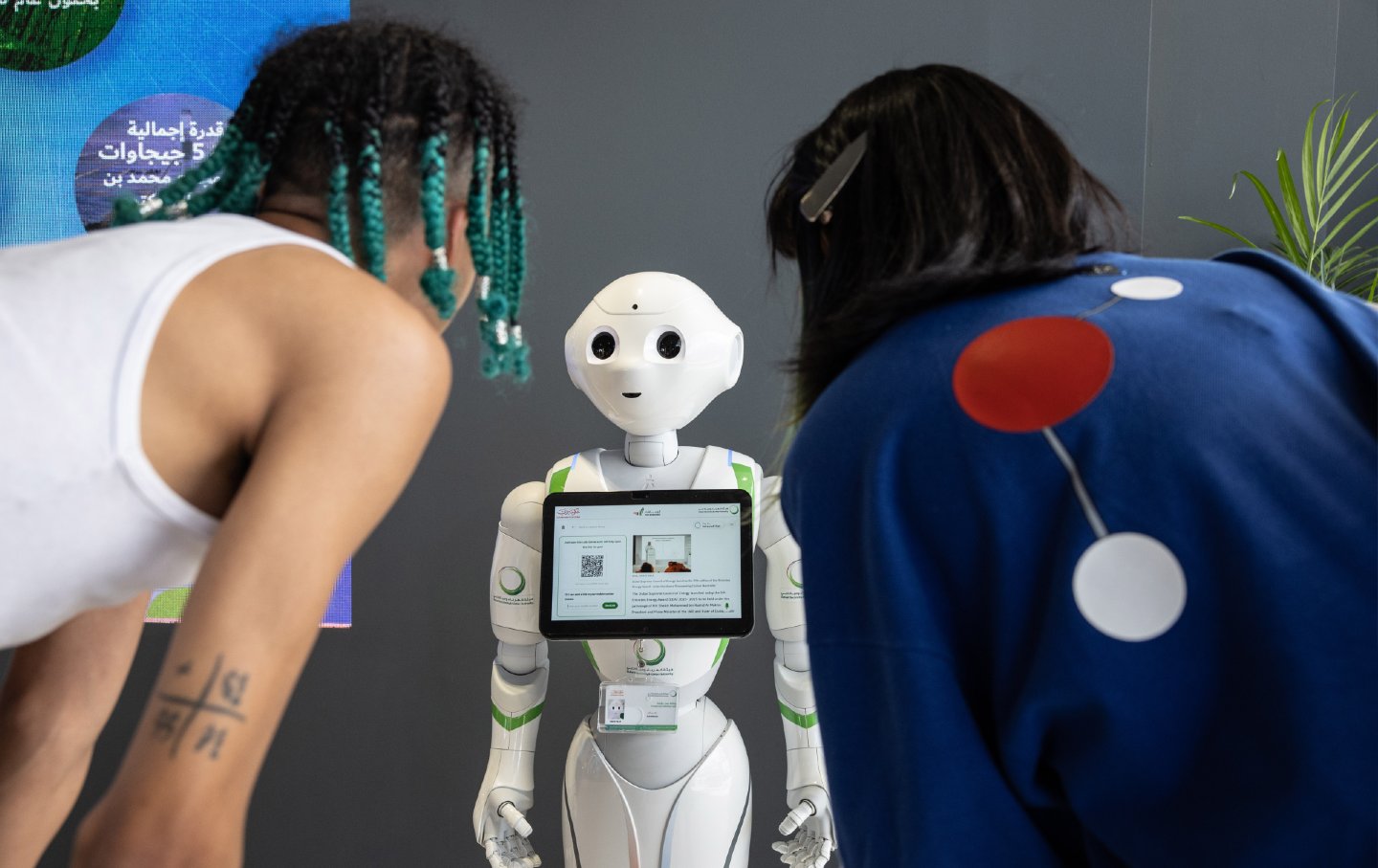 Attendee interact with a SoftBank Group Corp. Pepper humanoid robot at the COP28 Climate Conference.