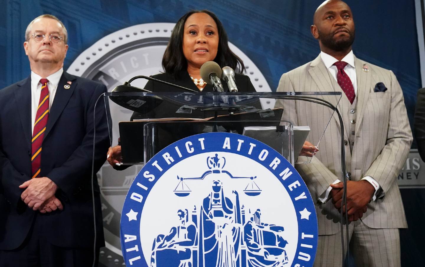 Fulton County District Attorney Fani Willis, center, speaks at a news conference alongside prosecutor Nathan Wade, right.
