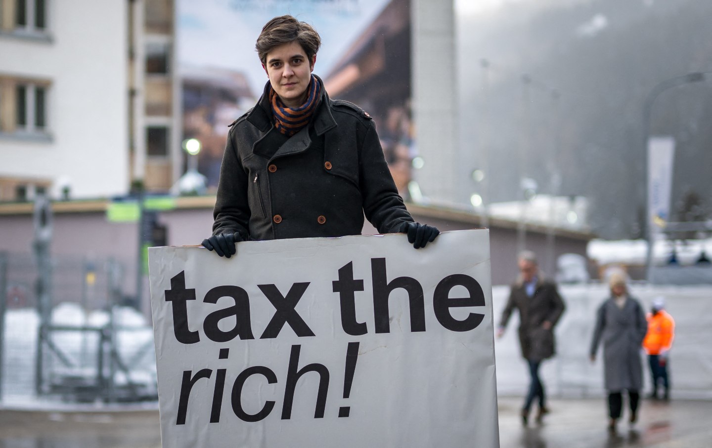 Austrian Marlene Engelhorn, whose family owns Germany's chemical giant BASF, poses with a placard reading “tax the rich!”