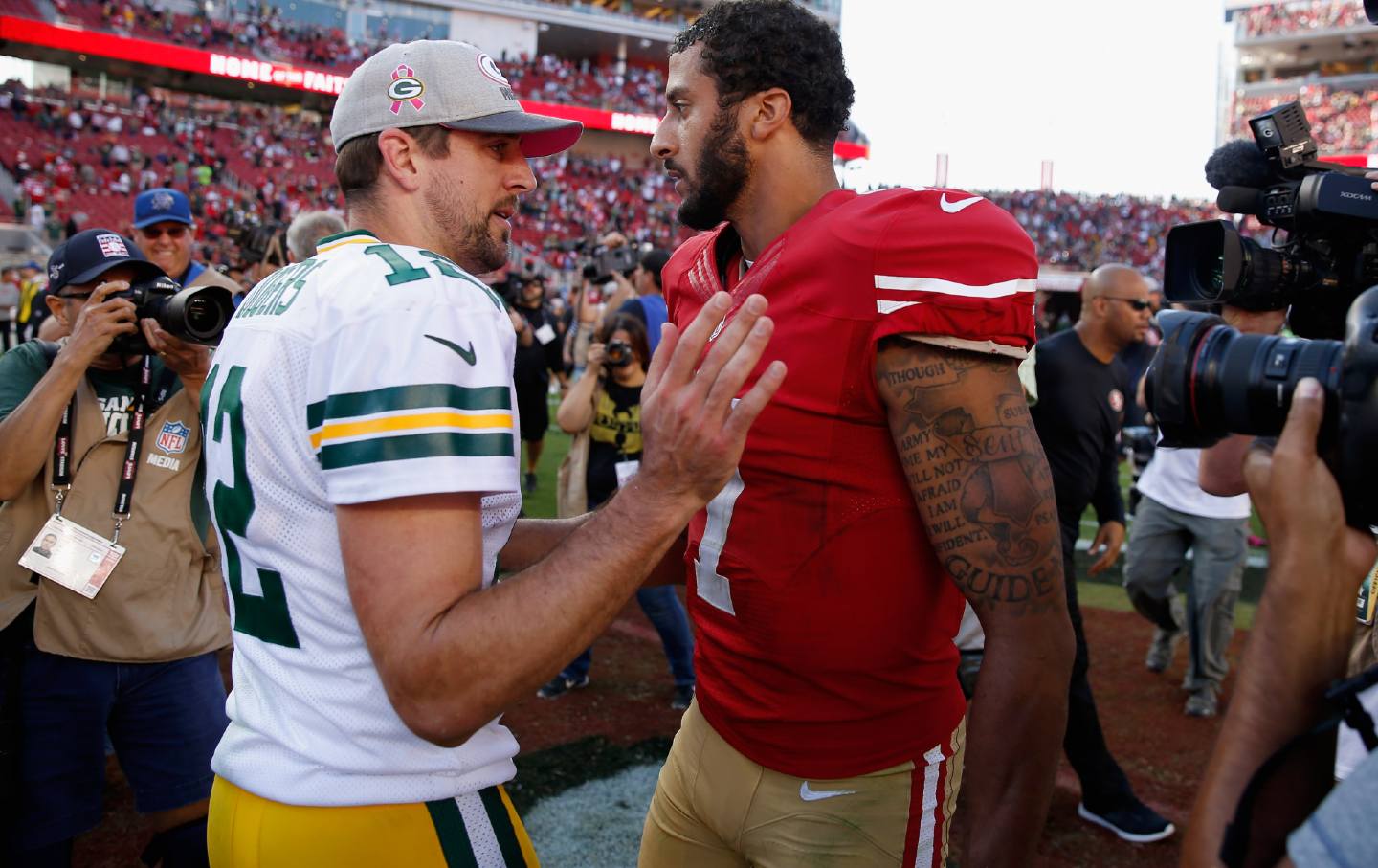 Colin Kaepernick, #7 of the San Francisco 49ers, talks with Aaron Rodgers, #12 of the Green Bay Packers, after their game on October 4, 2015, in Santa Clara, Calif.