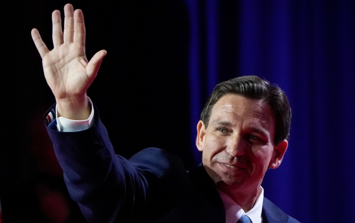 Governor of Florida Ron DeSantis waves as he departs the stage.