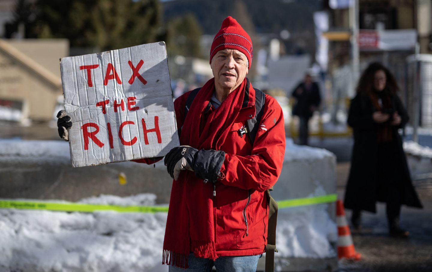 Phil White, a British millionaire, poses with a placard that reads 