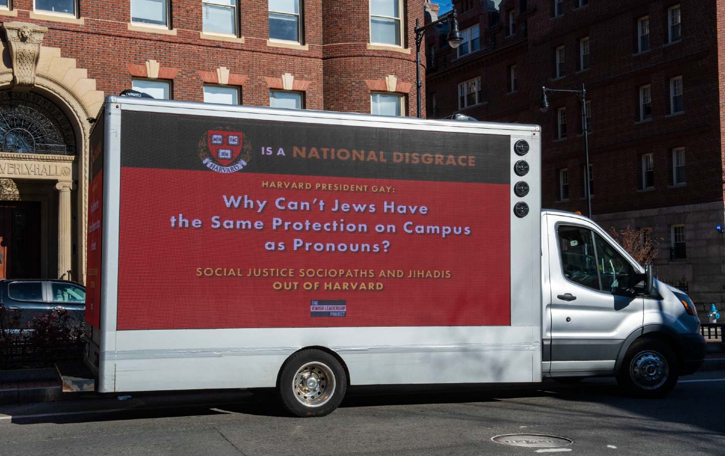 A truck carrying a sign calling the president of Harvard a disgrace drives around Harvard University in Cambridge, Mass., on December 12, 2023.
