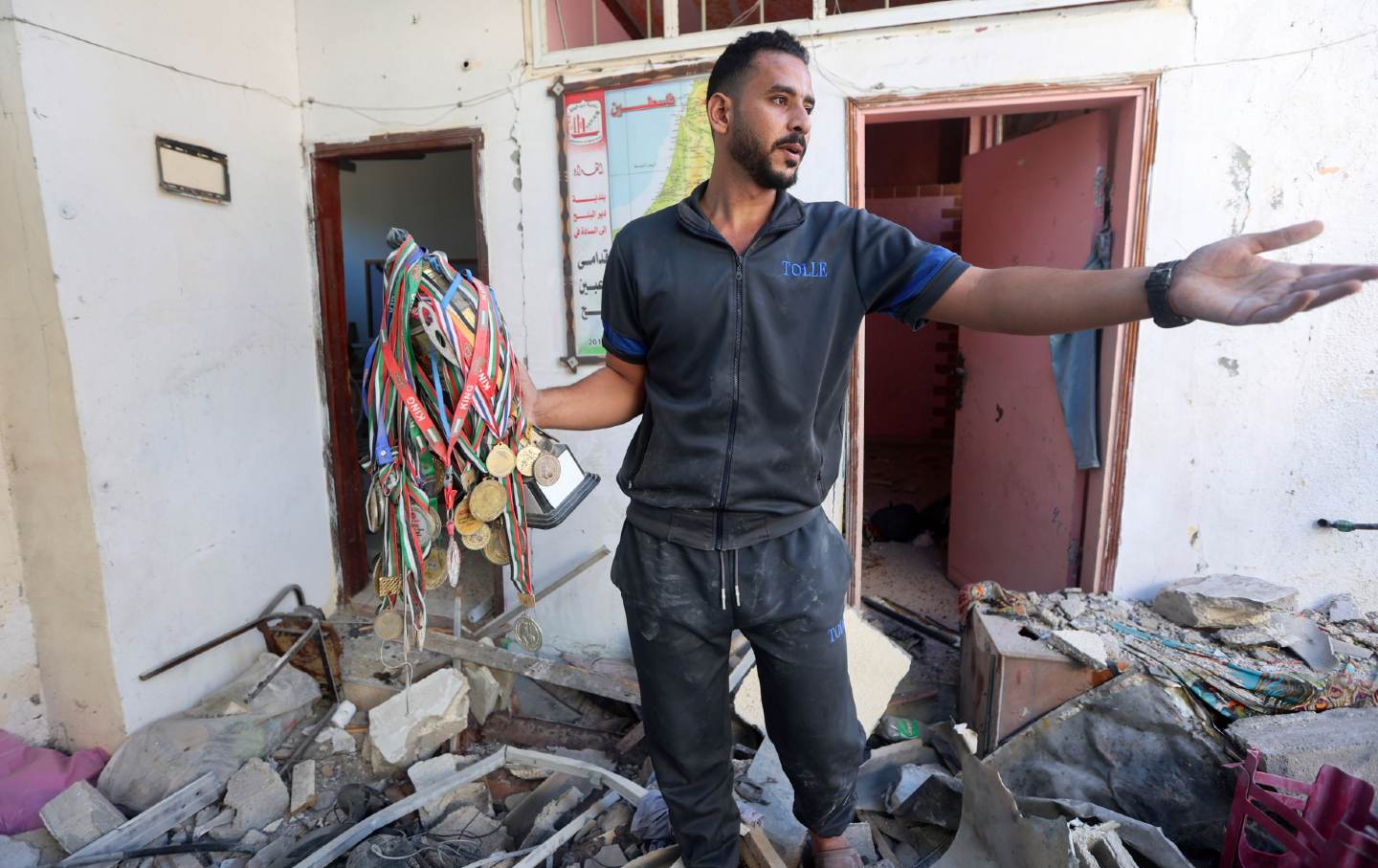 Former Palestinian football player Said al-Kurd carries recovered medals from his destroyed family home where eight of his family members were killed following an Israeli shelling attack in Rafah in the southern Gaza Strip on October 30, 2023.