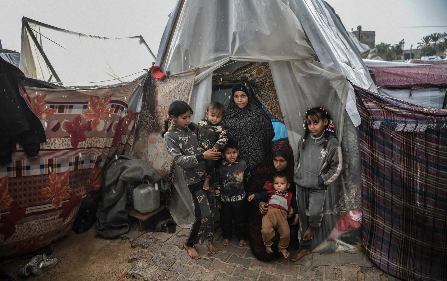 : Palestinian families are seen among tents as they struggle with strong winds, downpours and floods while Israeli attacks continue in Rafah of Gaza on February 15, 2024.