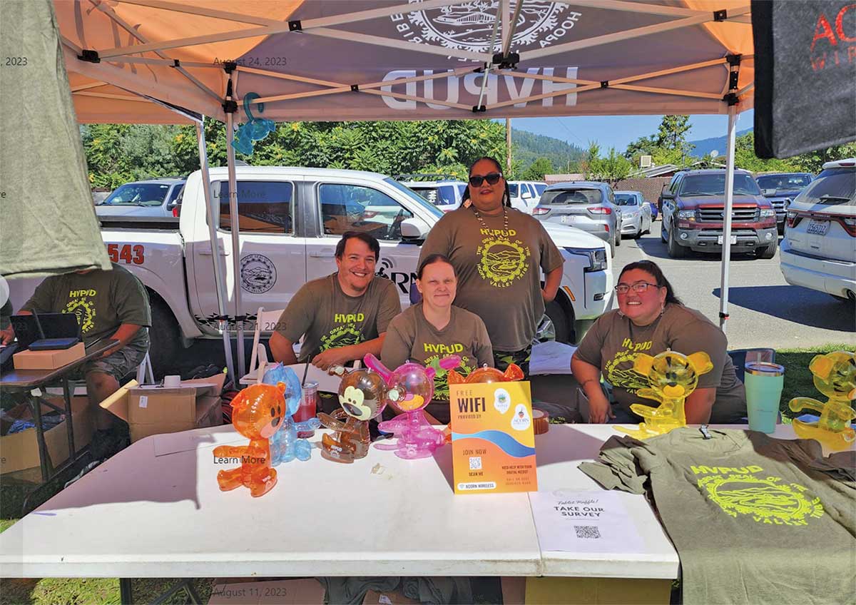 Employees of the Hoopa Valley Public Utilities District, including Linnea Jackson (center), table at a trible event.