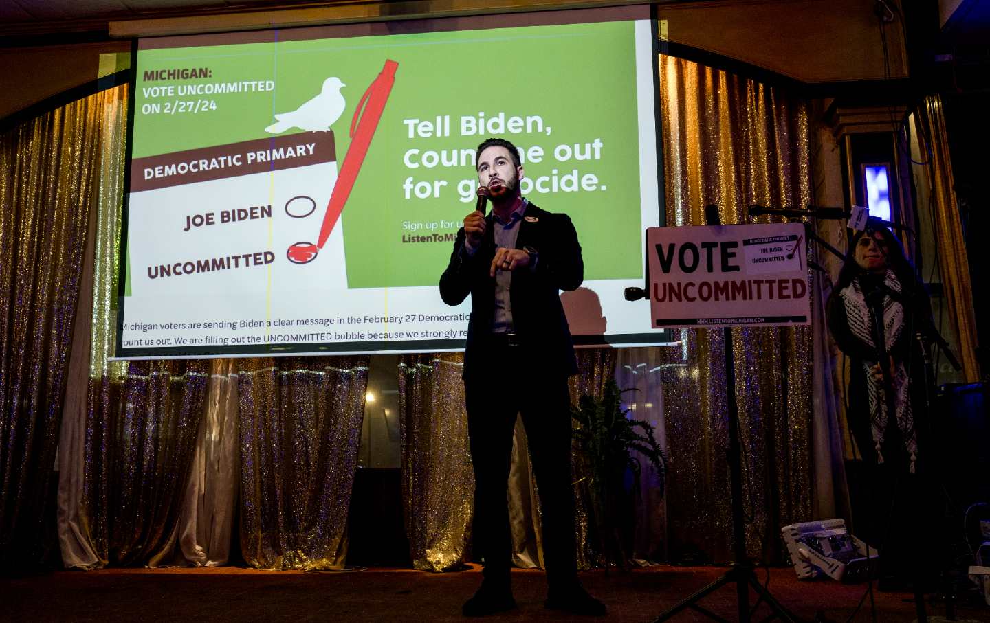 Abdullah Hammoud, the mayor of Dearnborn, stands with a microphone on stage and speaks at an election night gathering