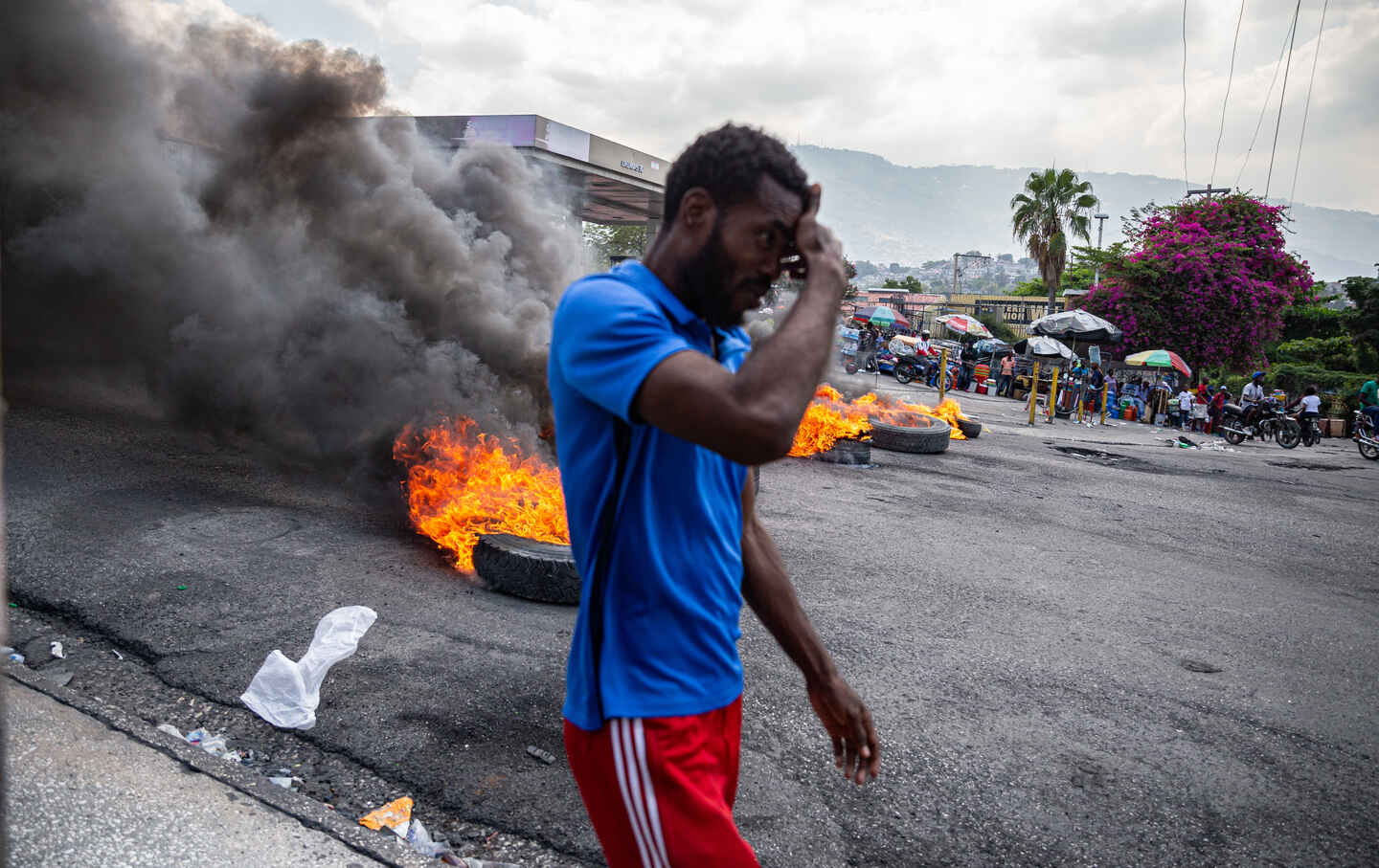 A man walks past burning tires during a demonstration against CARICOM following the resignation of Haitian Prime Minister Ariel Henri on March 12, 2024.