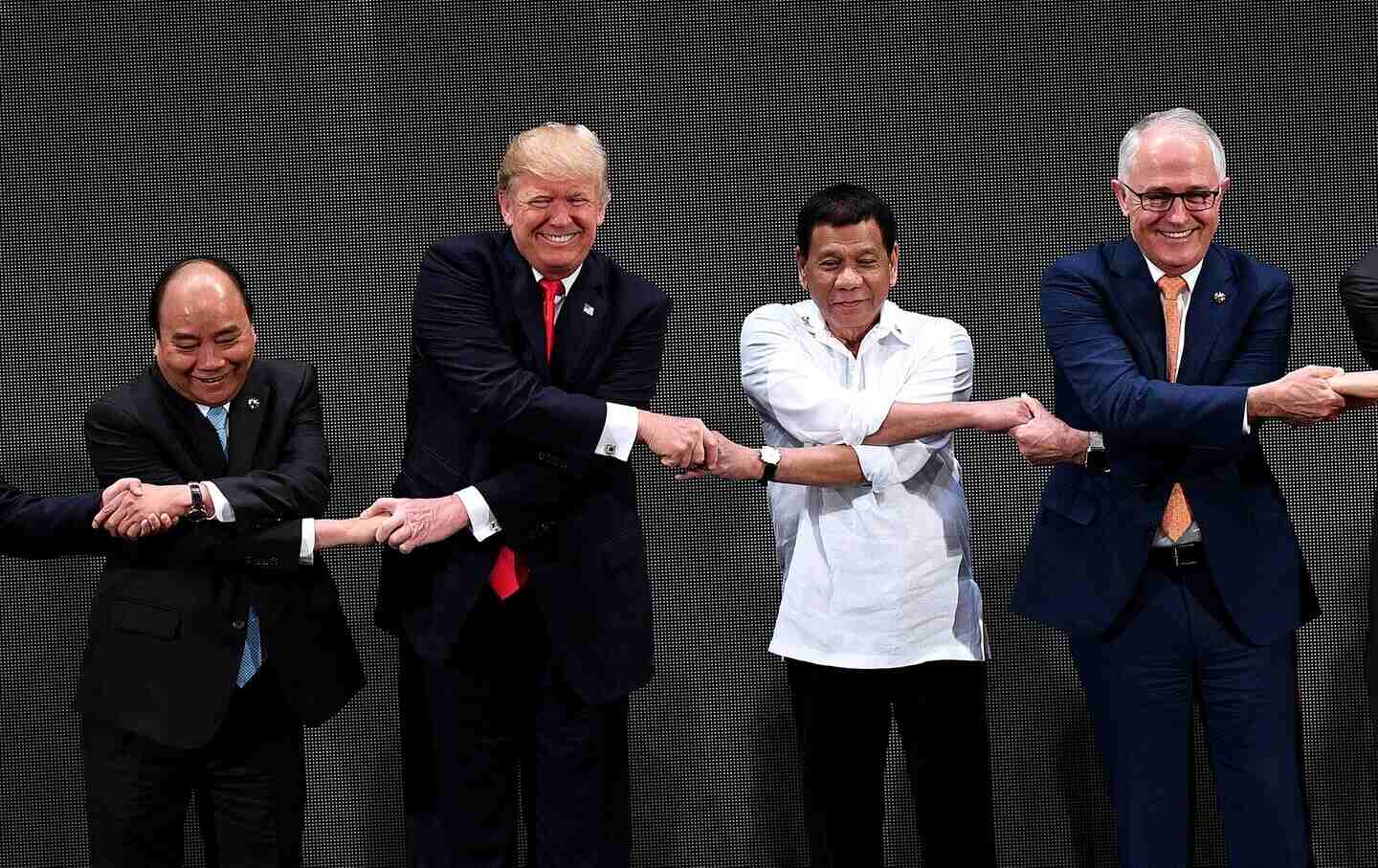 The Association of Southeast Asian Nations (ASEAN) members Vietnam's Prime Minister Nguyen Xuan Phuc, US President Donald Trump, Philippine President Rodrigo Duterte, Australia Prime Minister Malcolm Turnbull, link hands during the Opening ceremony of the 31st ASEAN Summit in Cultural Center of the Philippines in Manila on November 13, 2017.