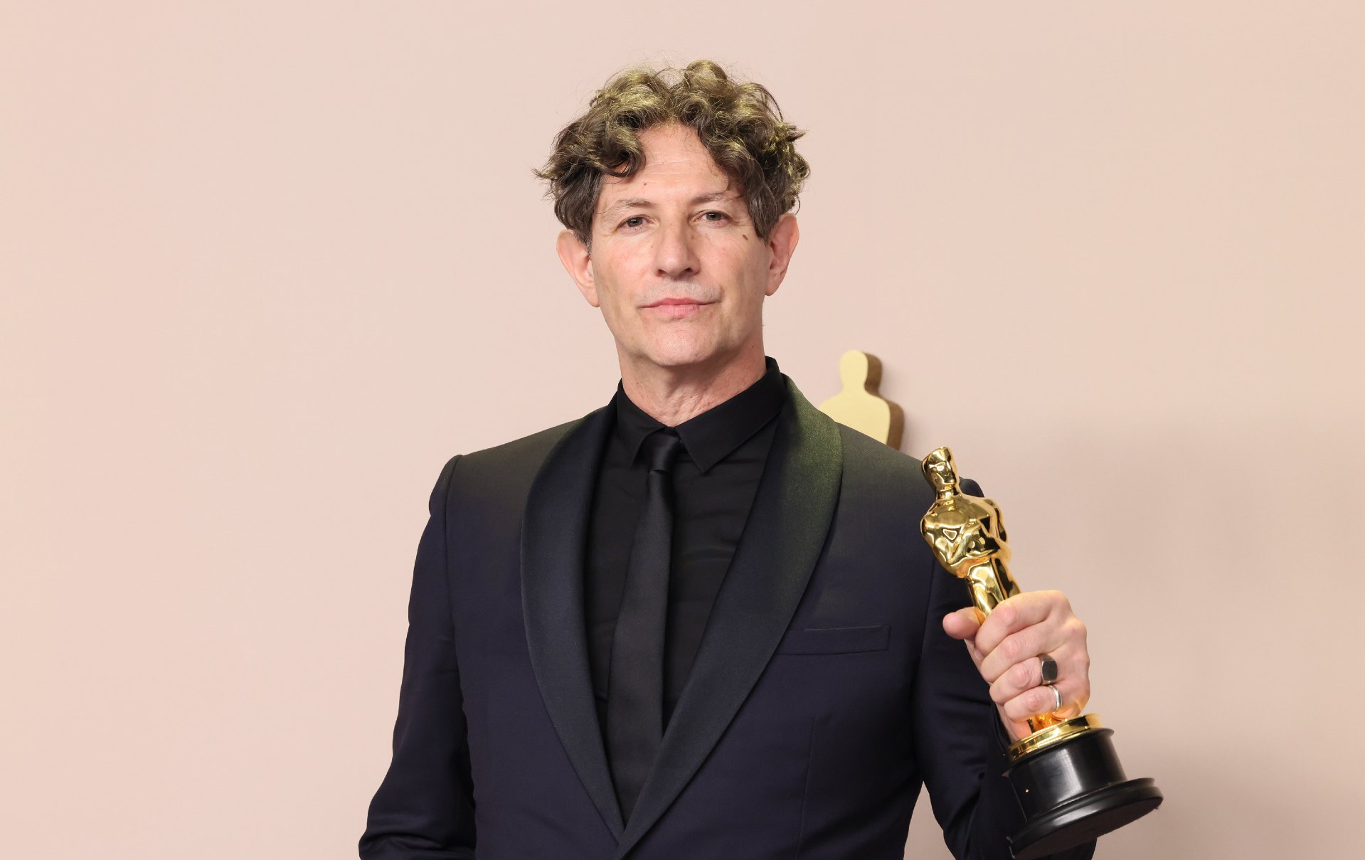 Jonathan Glazer holds an Oscars statuette