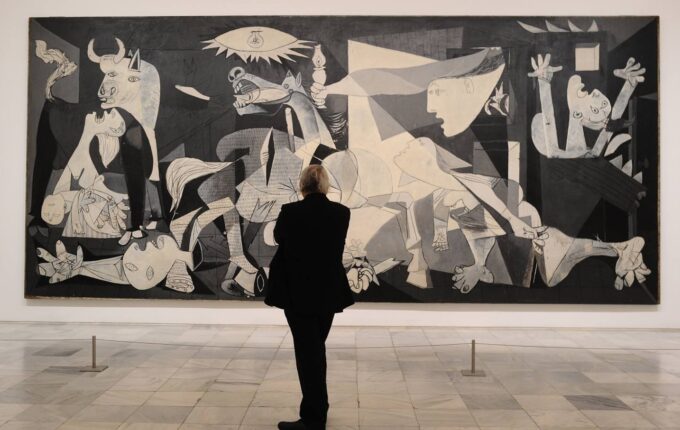 A person views Pablo Picasso’s “Guernica” at the Museo Reina Sofia in Madrid on April 3, 2017.