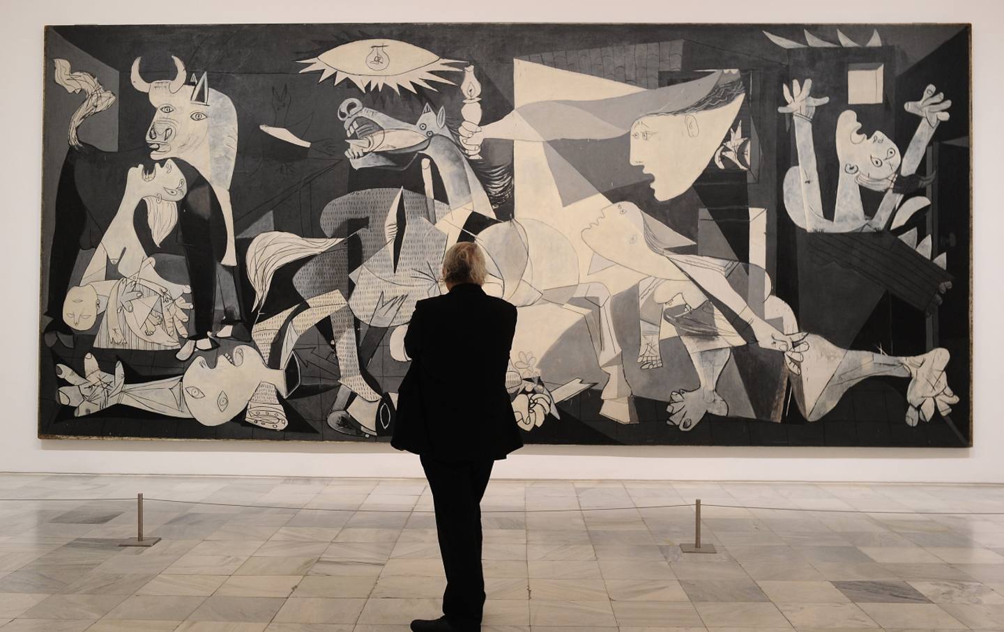 A person views Pablo Picasso’s “Guernica” at the Museo Reina Sofia in Madrid on April 3, 2017.