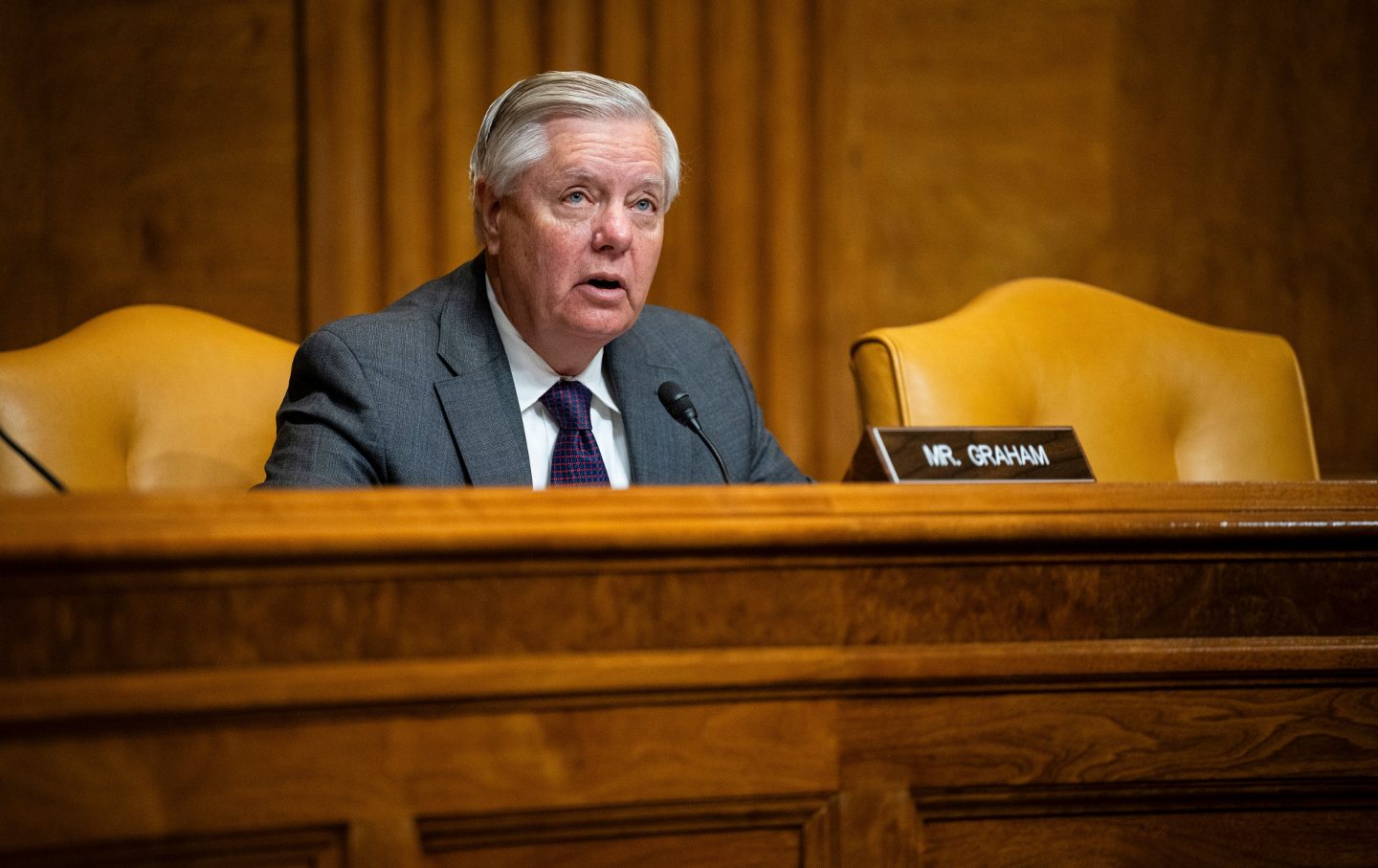 Sen. Lindsey Graham at a dias in front of a nameplate.