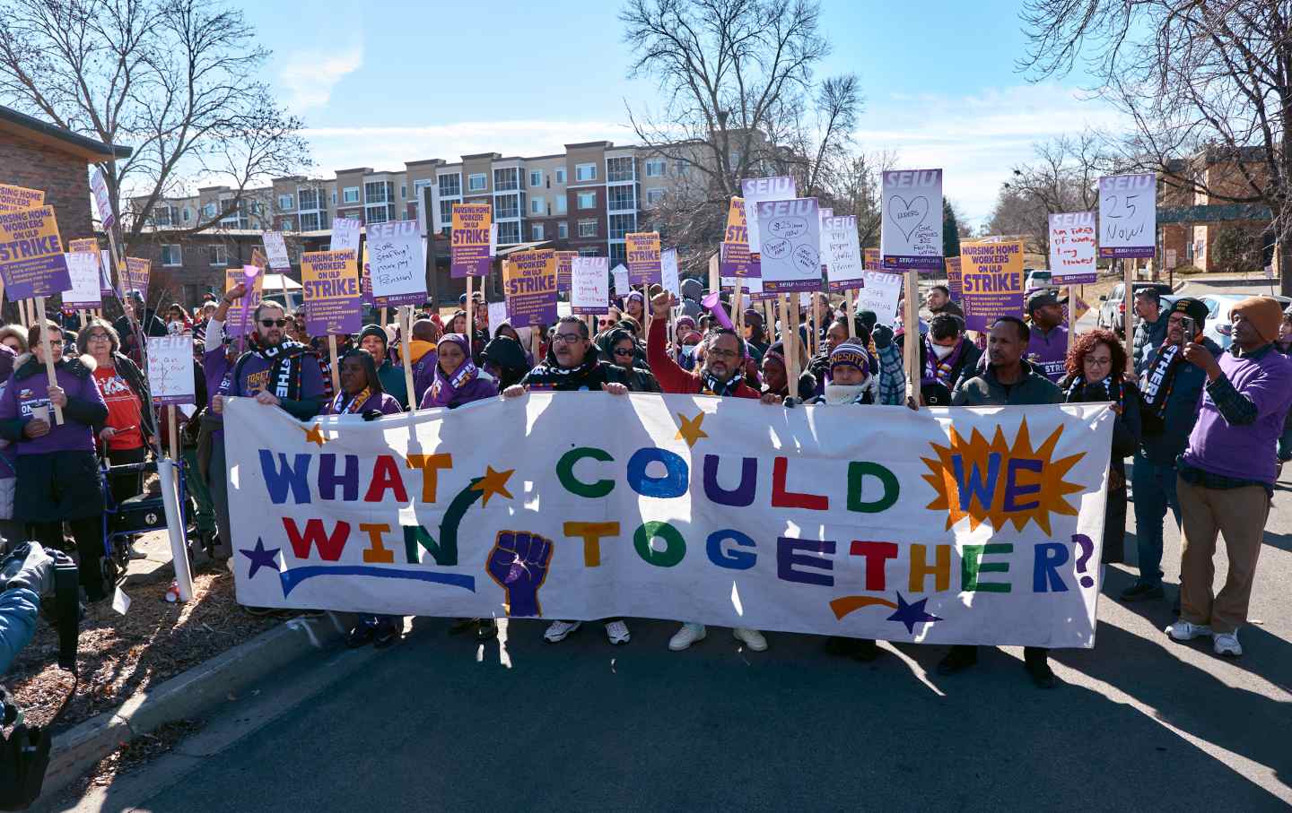 Union workers at a march holding a banner reading, 