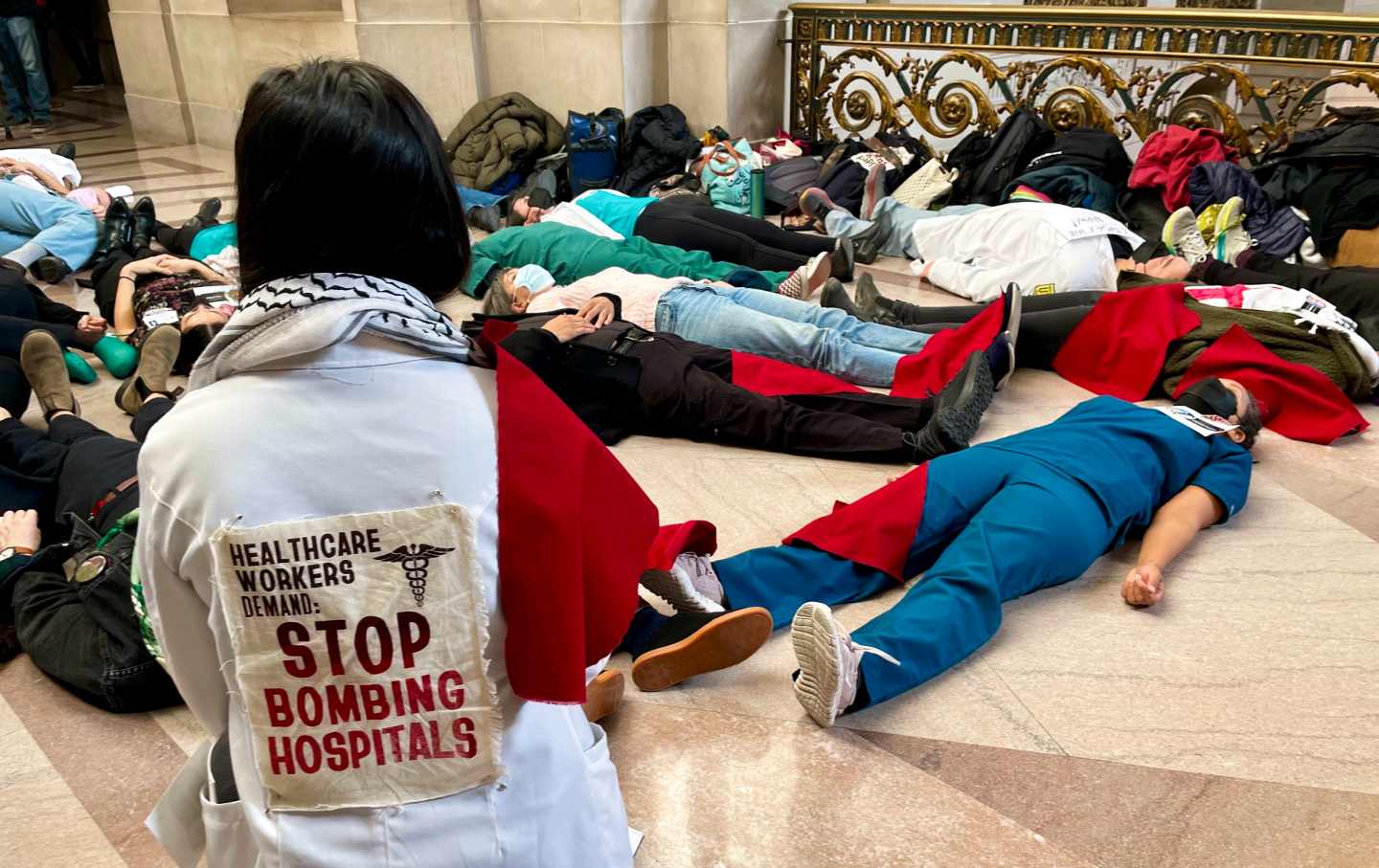 Healthcare workers stage a die-in to protest the assault on Gaza at San Francisco City Hall on January 8, 2024.