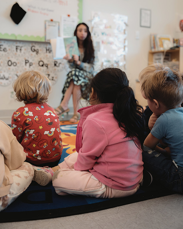 A teacher reads to kids in the daycare center at the Family Promise shelter in Bozeman.