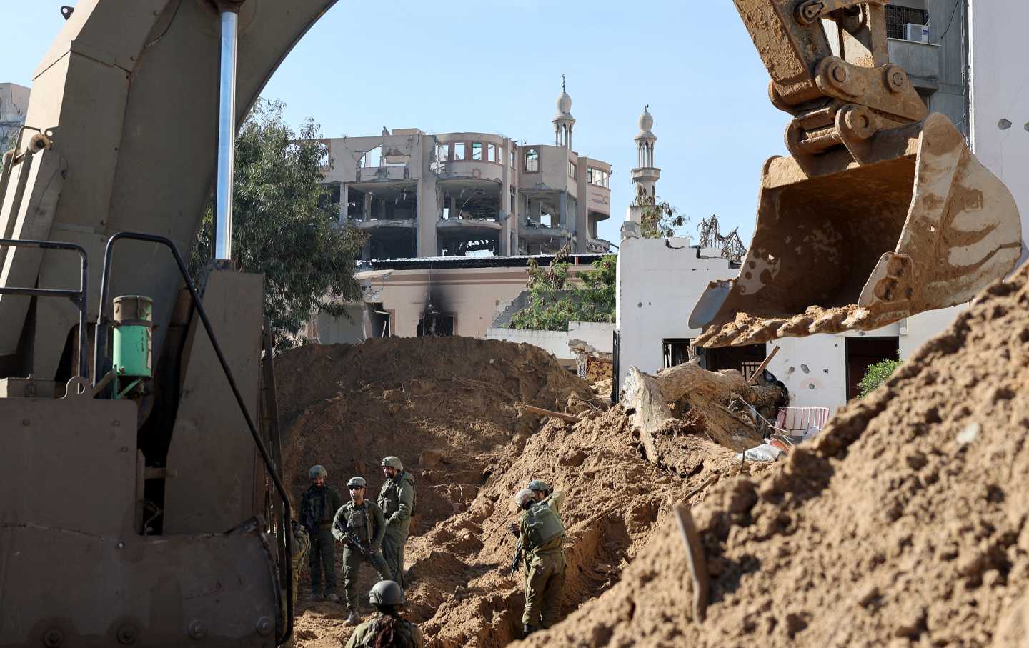 This picture taken during a media tour organized by the Israeli military on February 8, 2024, shows Israeli soldiers standing near a bulldozer inside Gaza City.