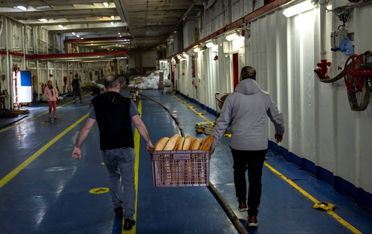 Bread is carried on board as workers prepare a ship from the Freedom Flotilla Coalition while it anchors in the Tuzla seaport, in Istanbul on April 19, 2024.