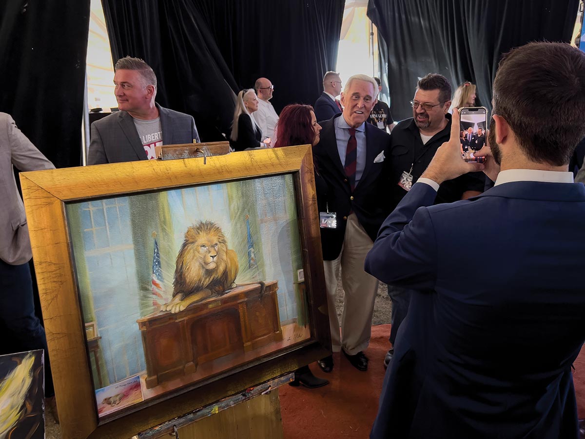 Roger Stone with a painting titled Lion of Judah on the Resolute Desk at the ReAwaken America Tour.