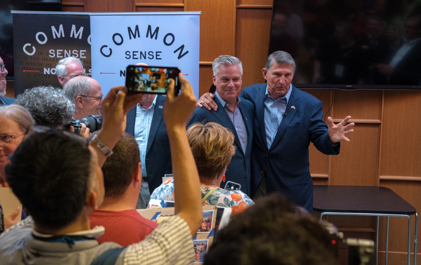 Senator Joe Manchin III (D) and former Utah governor Jon Huntsman (R) visit an overflow room after co-headlining the Common Sense Town Hall, an event sponsored by the bipartisan group No Labels, held on July 17, 2023, in Manchester, New Hampshire.