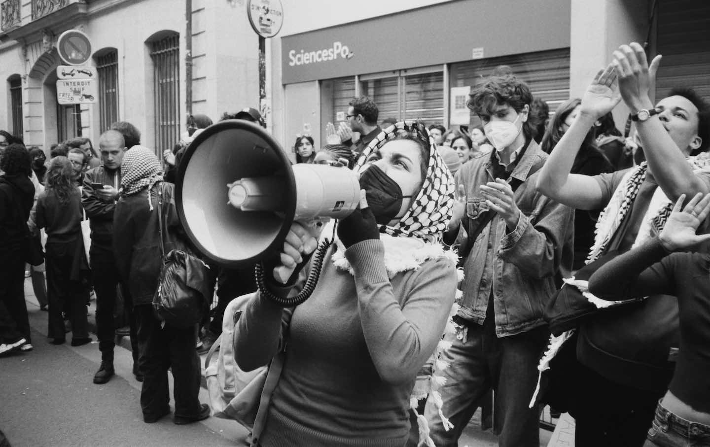 A student leads a chant on the street in front of Sciences Po on April 26.